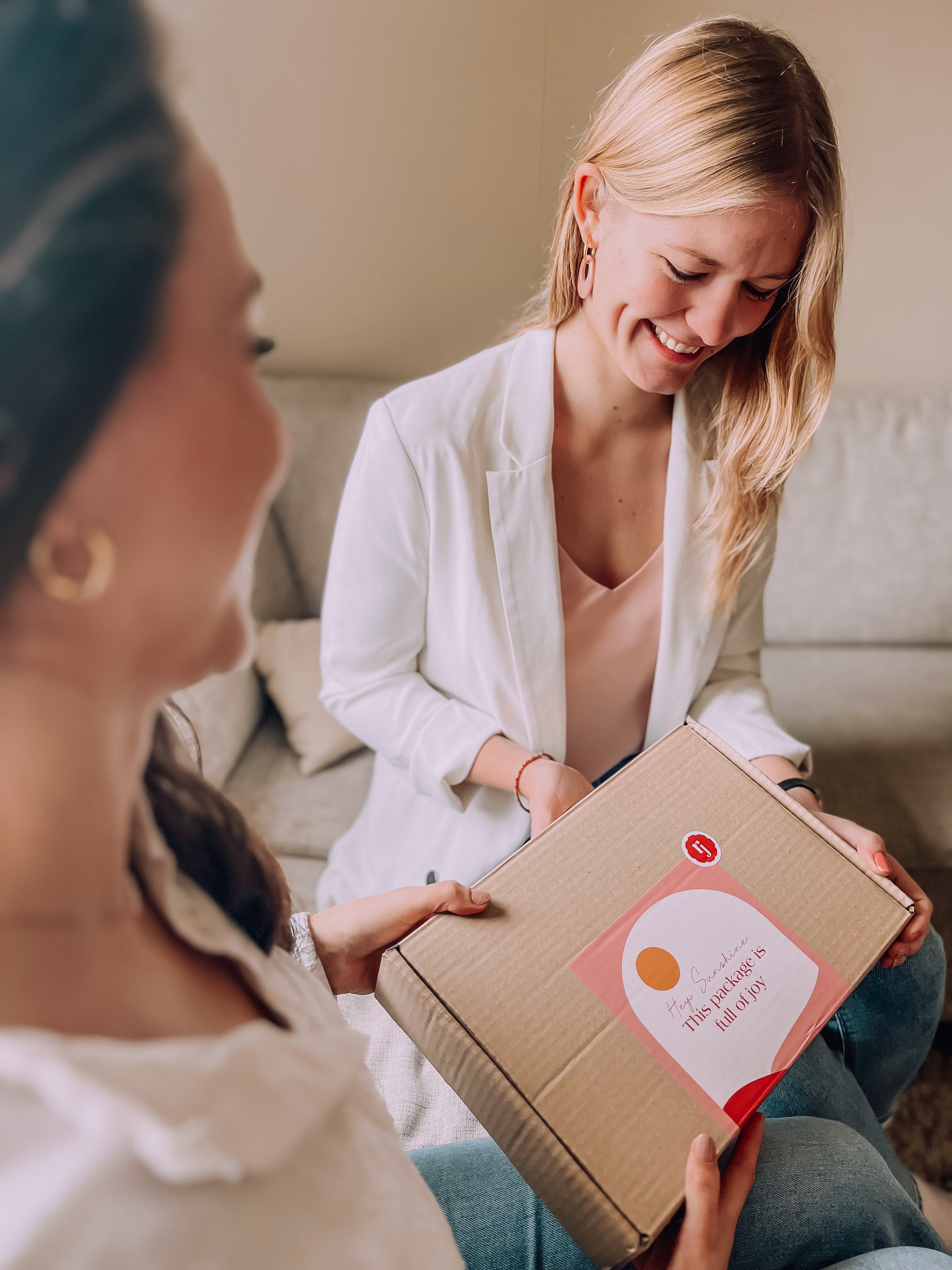 Een vrouw ontvangt met blijdschap een cadeau van Rejoyce