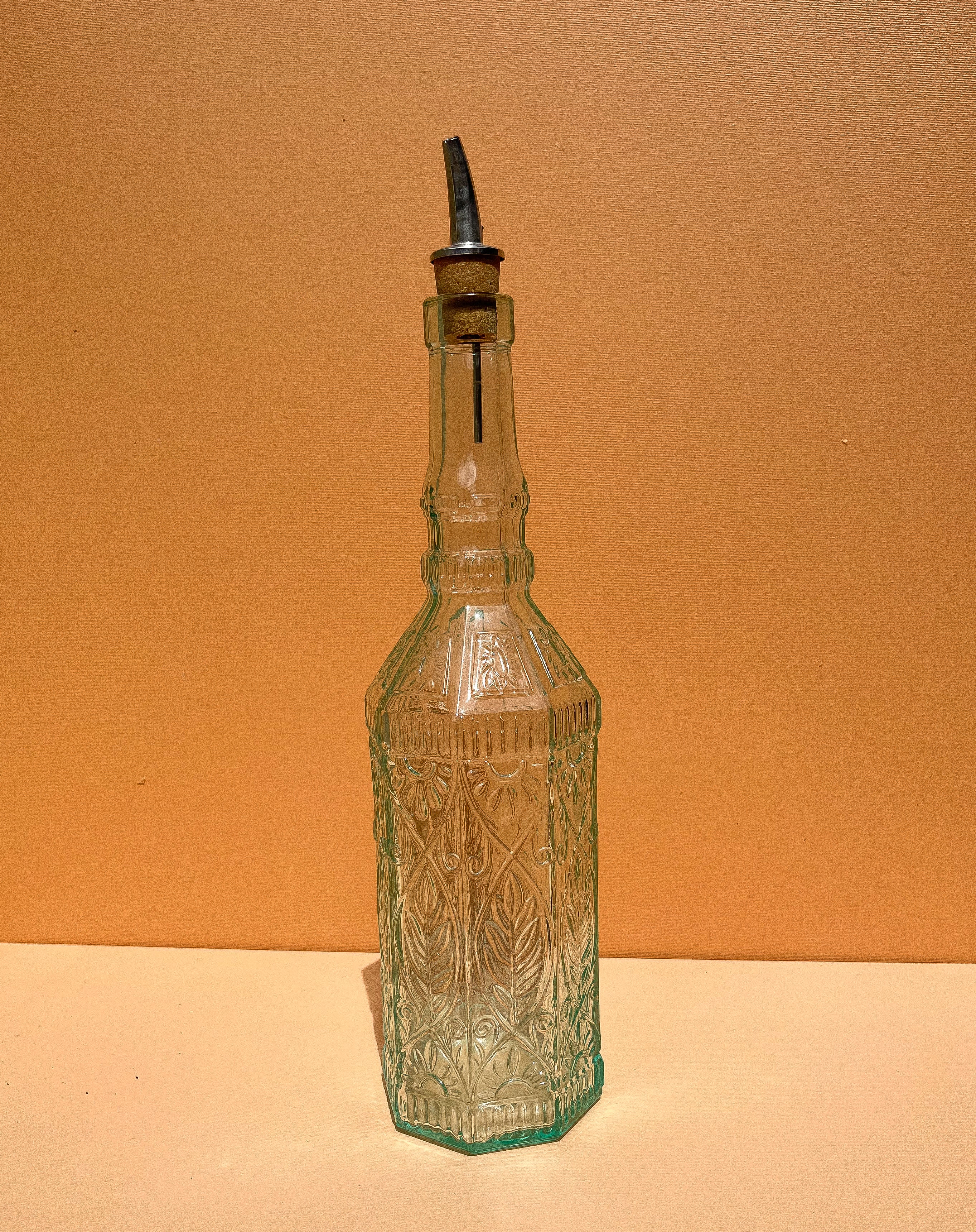 Glazen oliefles met motief